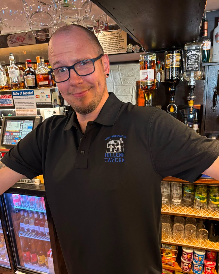 Chris Evenden behind the bar in a Hillend Tavern polo shirt