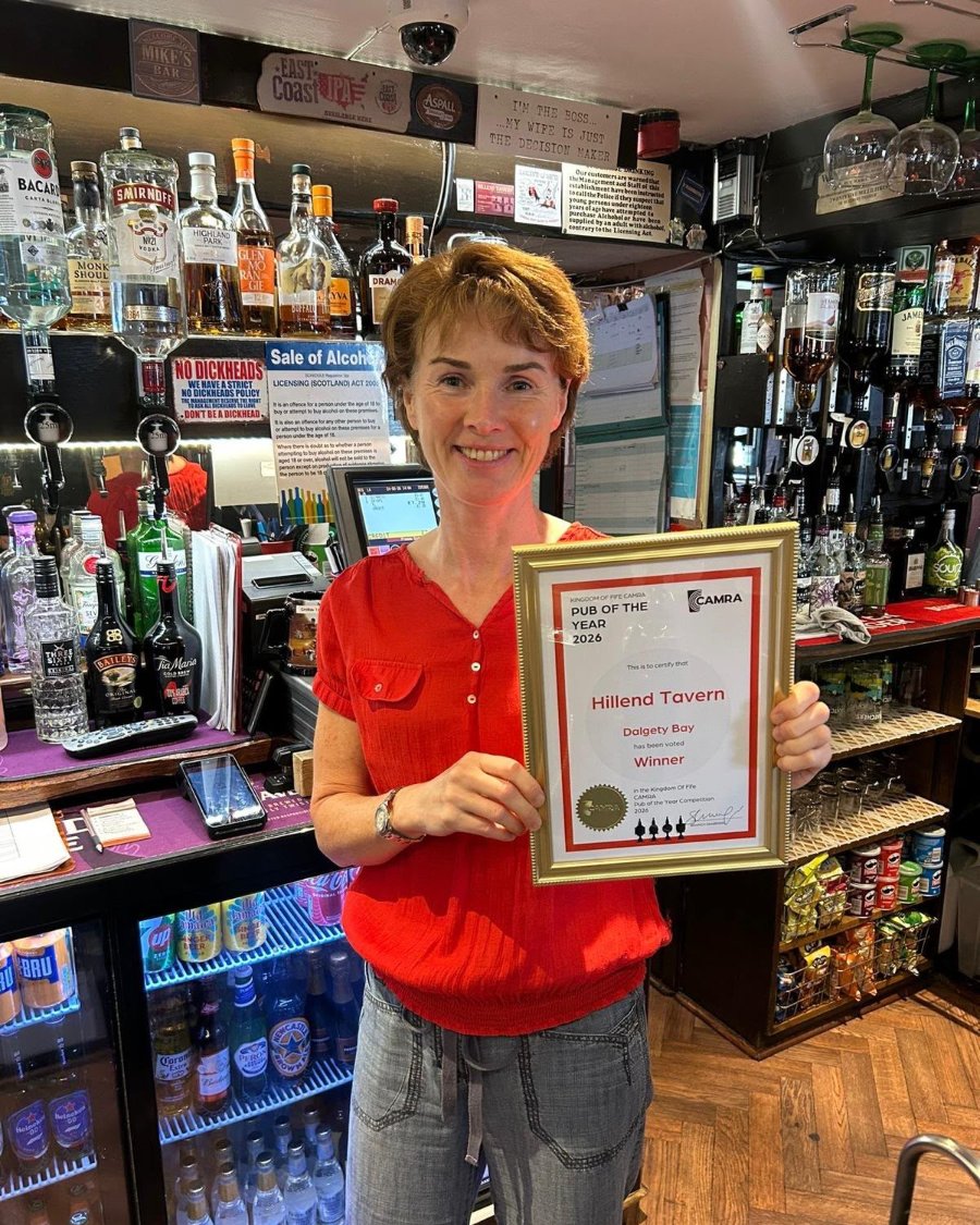 Lesley-Anne Mathieson holding the CAMRA Fife Pub of the Year 2026 certificate behind the bar